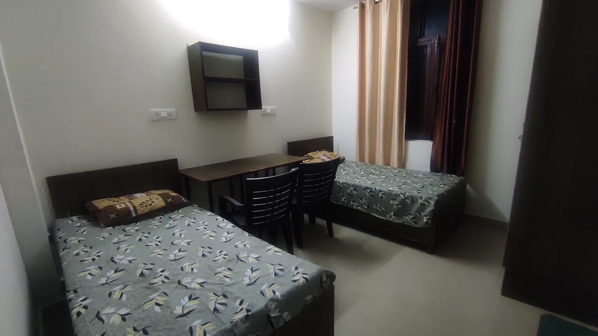 Cozy bedroom with study table at Daksh Home hostel near UPES Kandoli campus